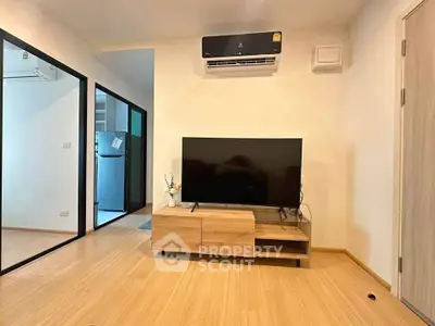 Modern living room with sleek TV setup and air conditioning in a cozy apartment.
