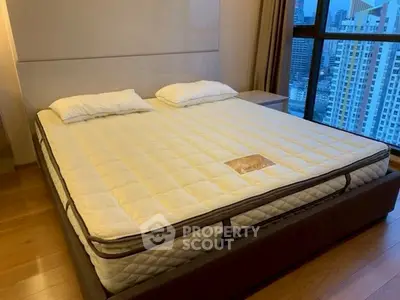 Spacious bedroom with large bed and city view, perfect for urban living.