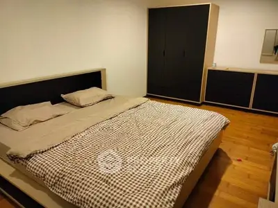 Cozy bedroom with modern furniture and wooden flooring, perfect for relaxation.