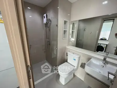 Modern bathroom with sleek fixtures and glass shower enclosure in a contemporary apartment.