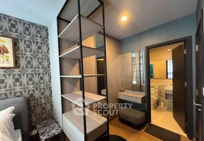 Modern bedroom with open shelving and ensuite bathroom in stylish apartment.