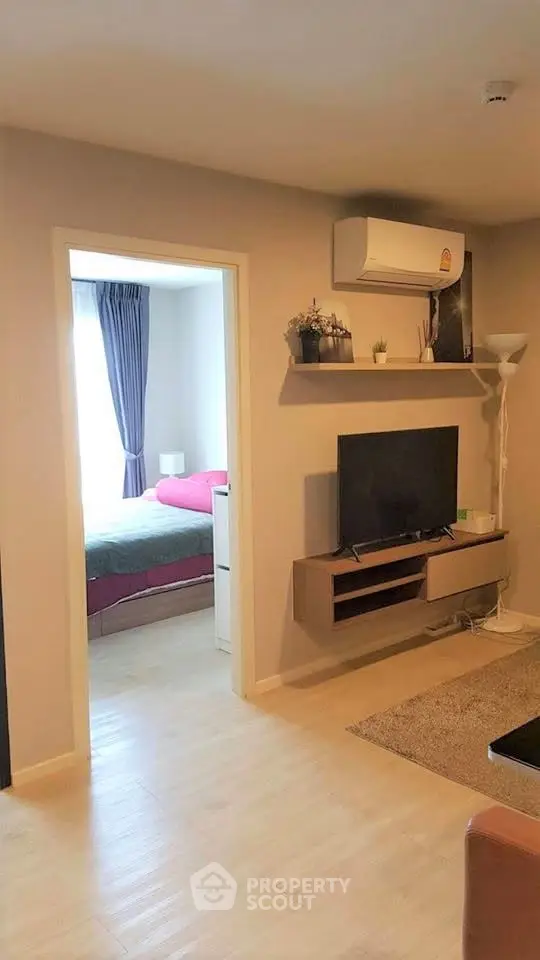 Modern apartment interior with cozy living room and view into a stylish bedroom, featuring sleek furniture and decor.