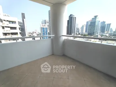 Spacious balcony with stunning city skyline views in modern high-rise building.