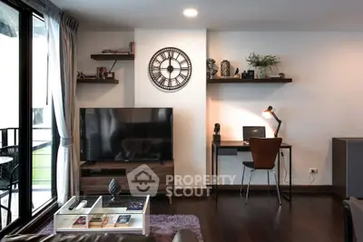 Modern living room with stylish decor, large TV, and cozy workspace in a contemporary apartment.