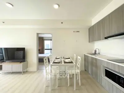 Modern open-layout living room and kitchen with dining area in a bright apartment.