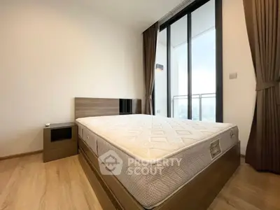 Modern bedroom with large window and wooden flooring