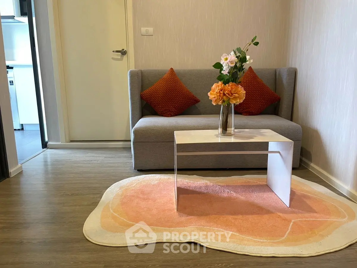 Cozy living room with modern sofa, vibrant cushions, and stylish coffee table on a chic rug.