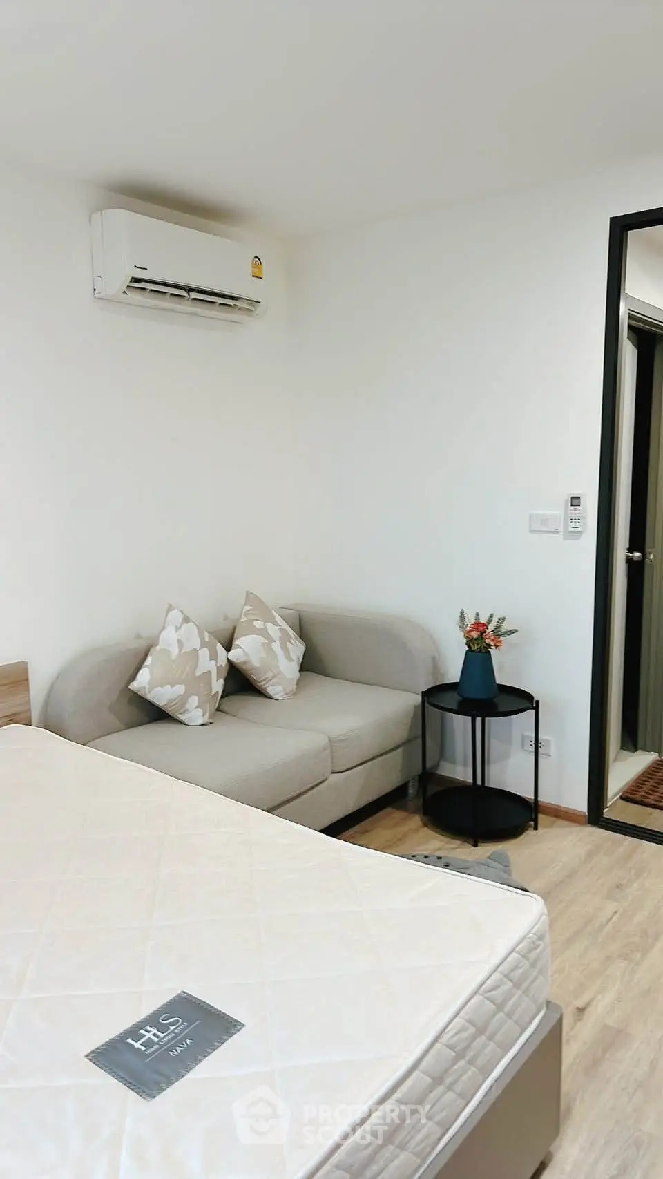 Modern bedroom with cozy sofa and air conditioning in a stylish apartment.