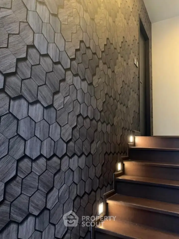 Modern staircase with unique hexagonal wall design and ambient lighting