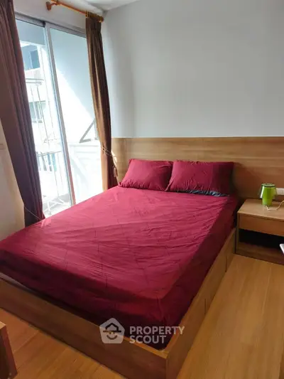Cozy bedroom with wooden flooring and balcony access in modern apartment