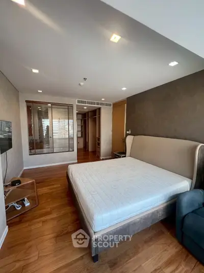 Spacious bedroom with modern design and wooden flooring in luxury apartment