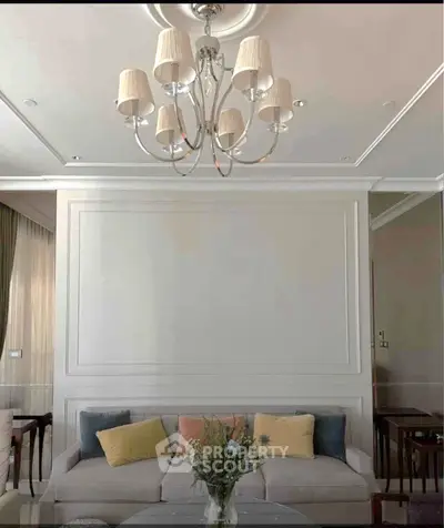Elegant living room with stylish chandelier and cozy sofa, perfect for modern living.