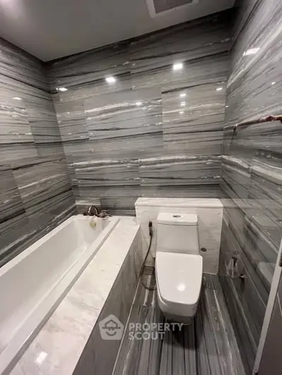Luxurious marble bathroom with modern bathtub and toilet