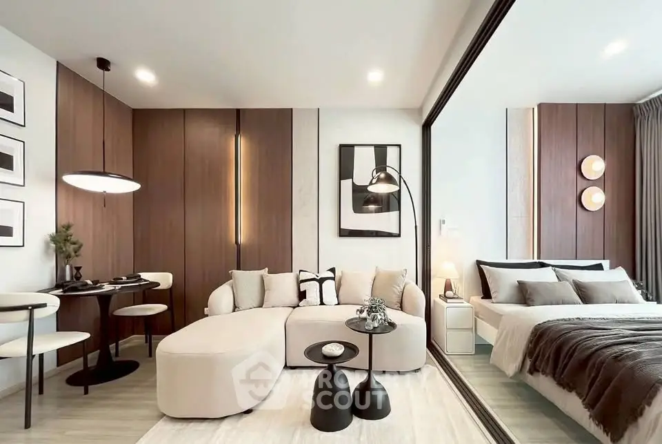 Modern open-plan living room and bedroom with stylish decor and neutral tones