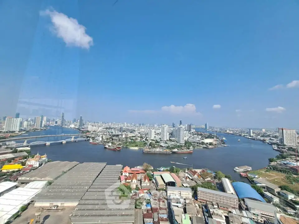 Stunning panoramic cityscape view of a river and skyline under a clear blue sky.