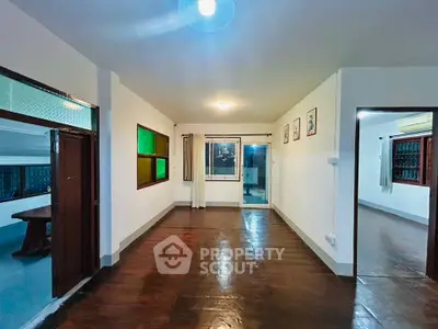 Spacious living room with wooden flooring and large windows in a modern home.
