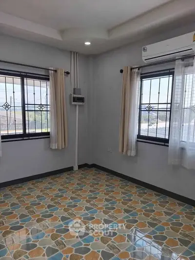 Bright room with colorful tiled floor and large windows, featuring air conditioning.