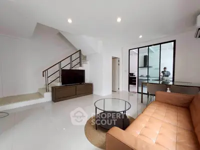 Modern living room with sleek staircase and open kitchen layout