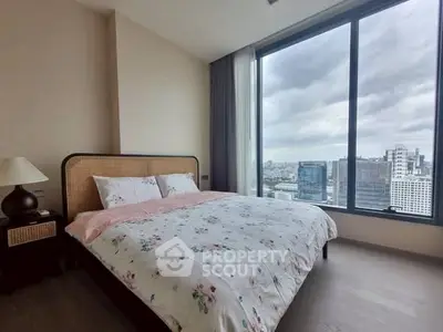 Modern bedroom with large window offering stunning city view