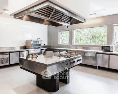 Spacious modern kitchen with stainless steel appliances and large windows