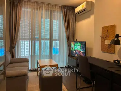 Modern living room with large windows, cozy sofa, and stylish decor in a high-rise apartment.