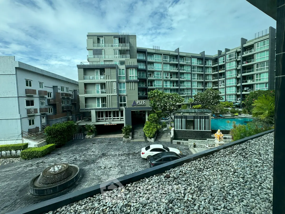 Modern apartment complex with pool and landscaped entrance, ideal for urban living.