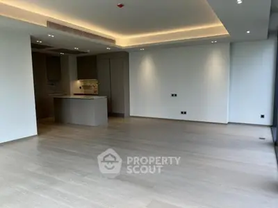 Spacious modern living room with open kitchen and elegant lighting