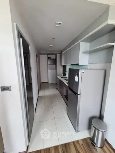 Modern kitchen with sleek appliances and open shelving in a stylish apartment.