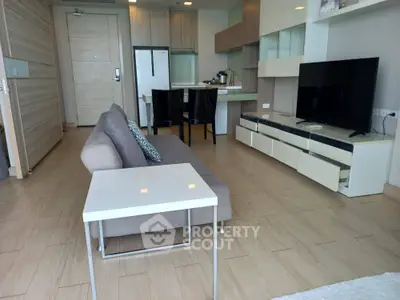 Modern living room with sleek furniture and open kitchen layout in a stylish apartment.