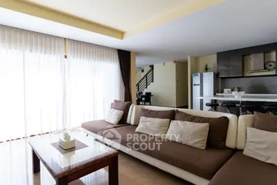 Spacious modern living room with open kitchen and natural light