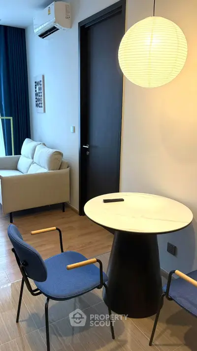 Modern living room with stylish furniture and elegant lighting, featuring a cozy seating area and contemporary decor.