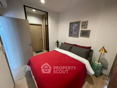 Cozy bedroom with red bedding and stylish decor in modern apartment