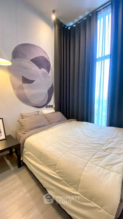 Modern bedroom with stylish decor and large window offering natural light.