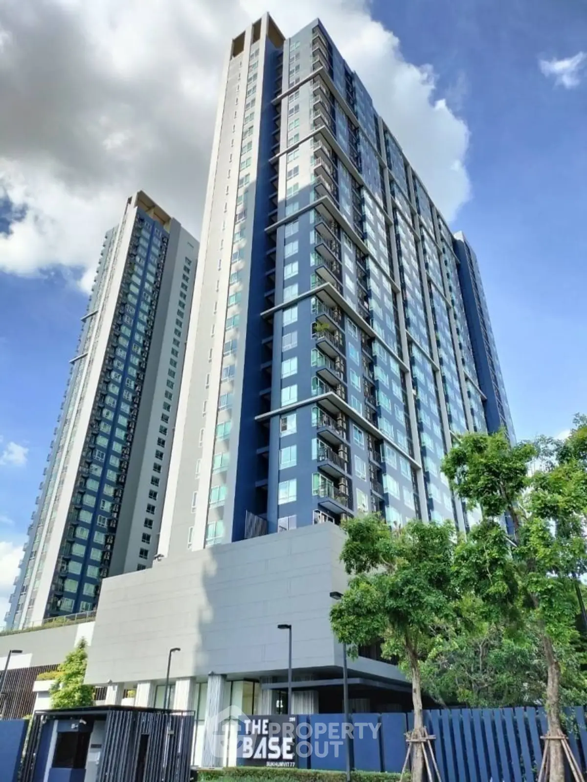 Modern high-rise building with sleek design and lush greenery, perfect for urban living.