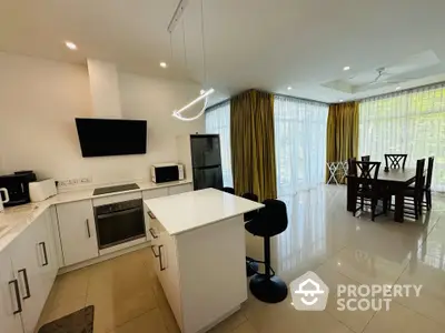 Modern open-plan kitchen and dining area with sleek appliances and natural light.