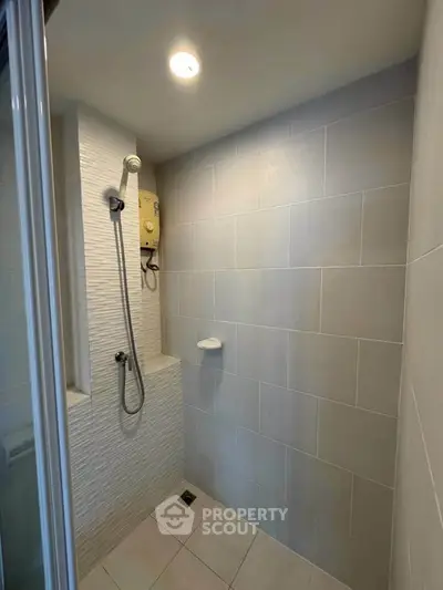 Modern bathroom shower area with sleek tiles and built-in shower head