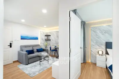 Modern apartment interior with cozy living room and stylish bedroom, featuring elegant decor and wooden flooring.