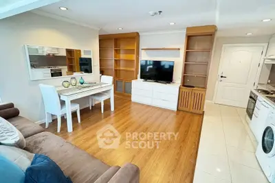 Spacious living room with modern open kitchen and elegant dining area, featuring wooden flooring and ample natural light.