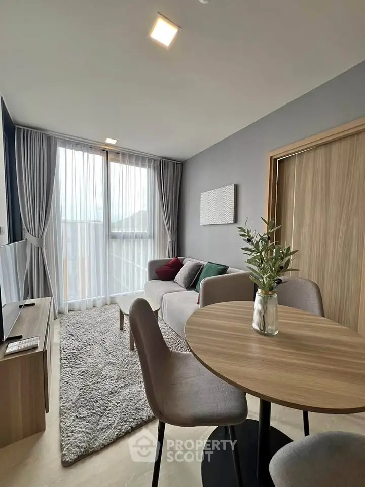 Modern living room with cozy sofa, dining table, and large window with curtains.