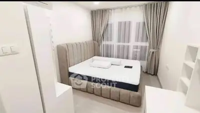 Modern bedroom with plush bed and elegant curtains in a bright, minimalist design.