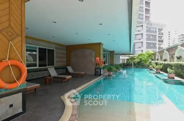 Luxurious condominium pool area with sun loungers and modern design, perfect for relaxation and leisure.