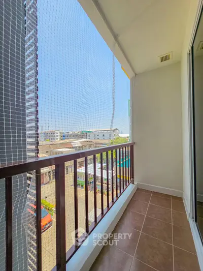 Spacious balcony with safety netting and city view, perfect for relaxation and enjoying the outdoors.