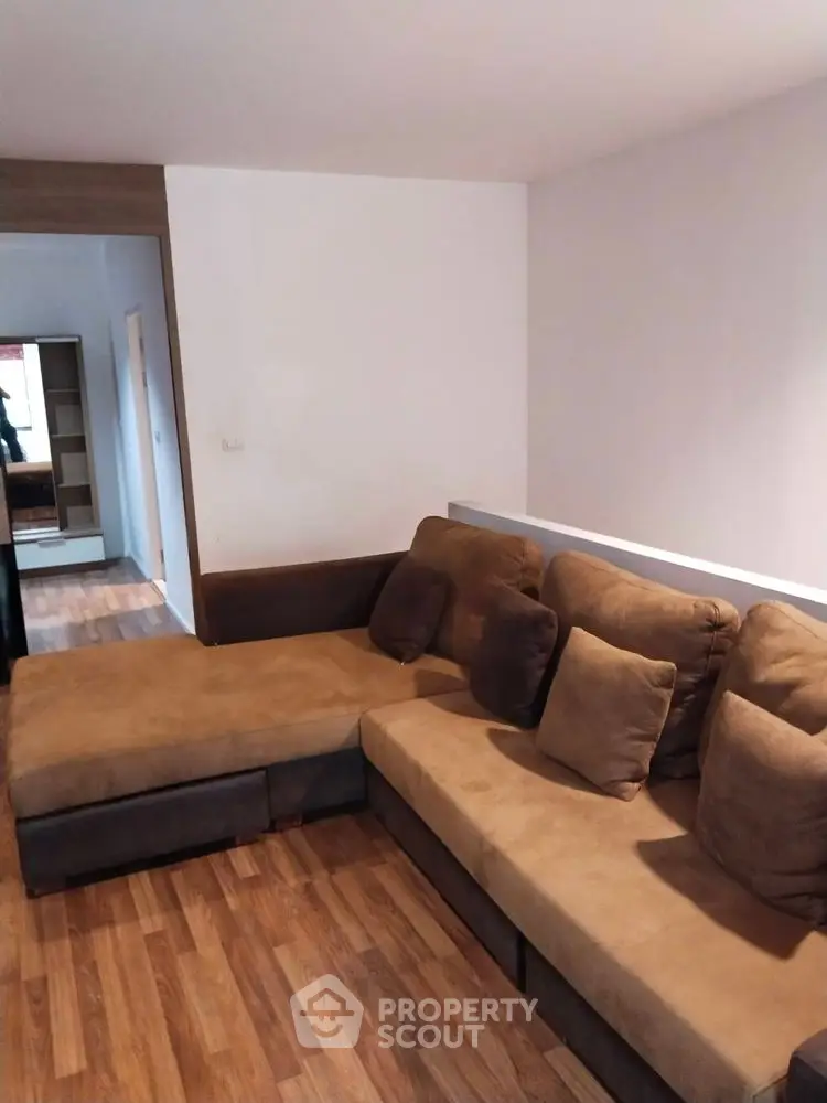 Cozy living room with brown sectional sofa and wooden flooring