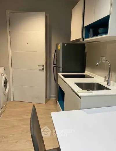 Modern compact kitchen with washing machine and sleek appliances