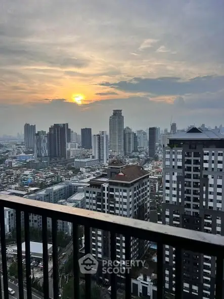 Stunning cityscape view from a high-rise balcony at sunset, showcasing urban skyline.