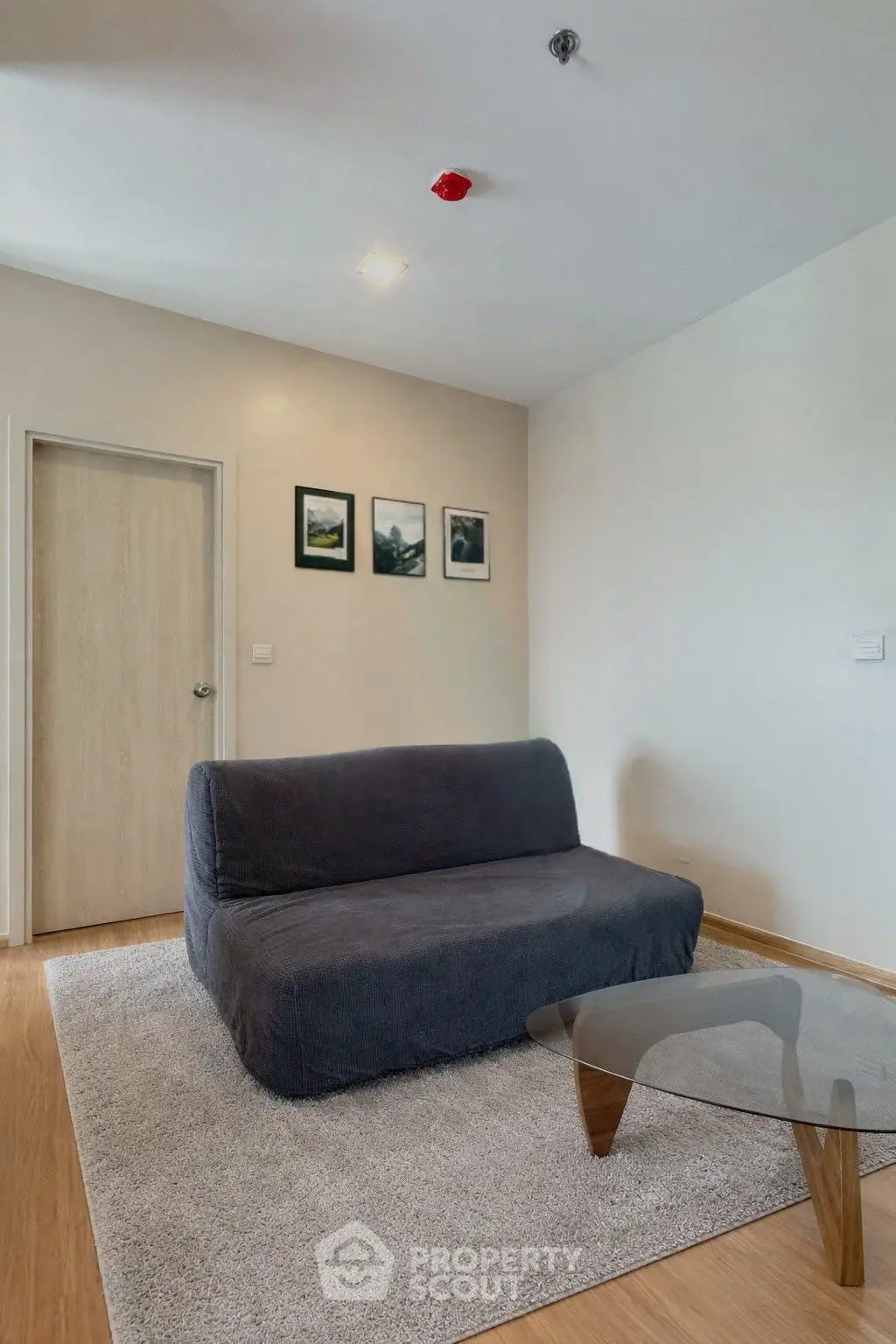 Modern living room with sleek sofa and glass coffee table, perfect for cozy relaxation.