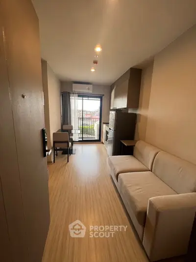 Modern living room with balcony view, featuring sleek furniture and open layout.