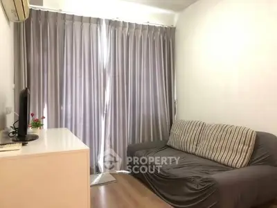 Cozy living room with modern sofa and elegant curtains, perfect for relaxation.