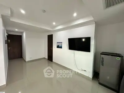 Modern minimalist living room with wall-mounted TV and sleek flooring.