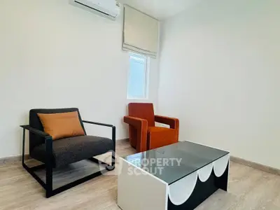 Modern minimalist living room with stylish armchairs and sleek coffee table.